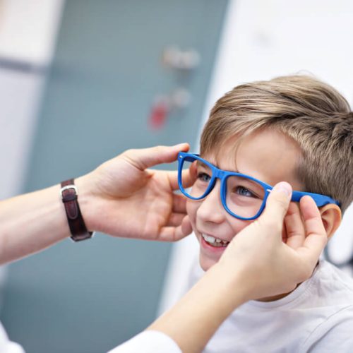 child optometry male optometrist optician doctor examines eyesight of little boy